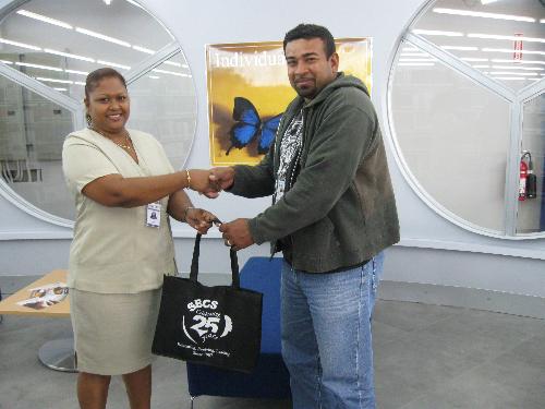 Sharon Beharry, Library Assistant, Champs Fleurs campus, presents Raymond Law with the SBCS token.